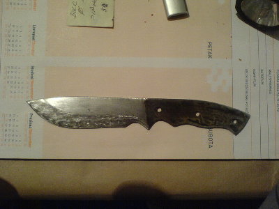 nakon popustanja s brenerom (grijao ledja dok ne poplave a ostrica bude smedje zlatna.... e pa nisam bas uspio ovaj put... zaboravio sam ponesti mali brener s posla pa sam radio sa 20mm koji imam kod kuce... pretjerao sam i sve je poplavilo... nemaveze... za iduci put kad budem radio vjerojatno nece ni trebati popustati jer cu samo kaljenje raditi na drugaciji nacin... a i imam ideju za bolje popustanje od ovoga s brenerom, ali o tome neki drugi put. Noz je pobrusen smirglom oko 150 cini mi se, pa s grubim kamenim brusom, pa onda sa finim... kasnije sam ga jos malo istrljao sa 240 ili tako nesto ali sa uljem, jer dok sam brusio sa vodom i kamenom, dok sam radio jednu stranu, druga je zahrdjala (u roku pola sata)